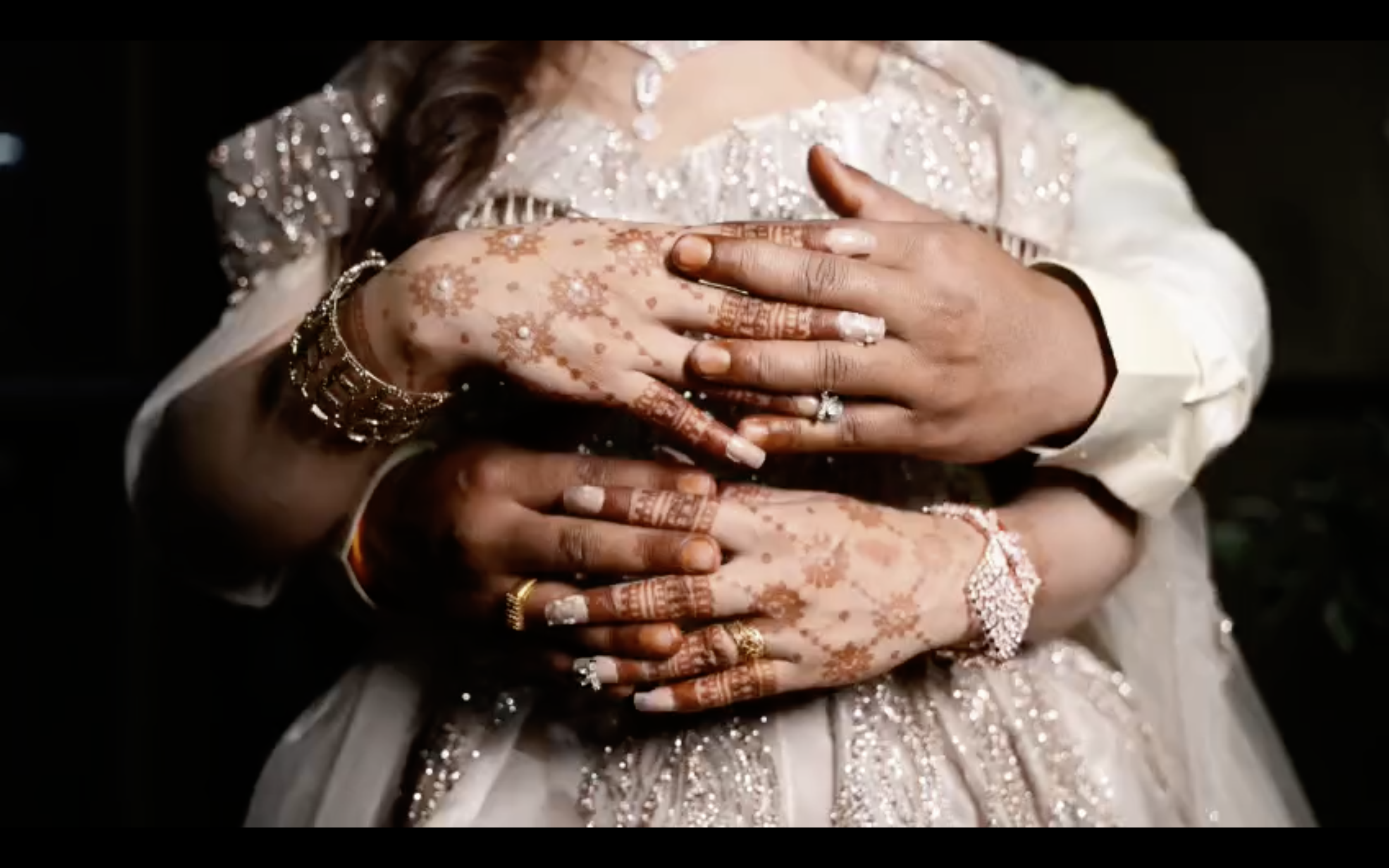 The couple dancing mid-twirl under string lights at the sangeet